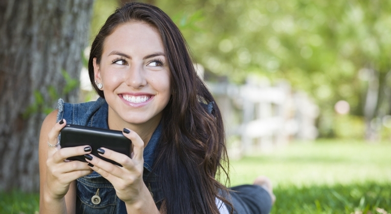 Smiling student using a smartphone.