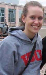 A woman with a ponytail and gray hoodie smiling.