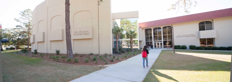 Student walks toward the college of education building