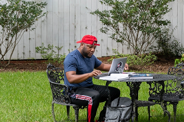 VSU online college student working on his laptop outdoors.