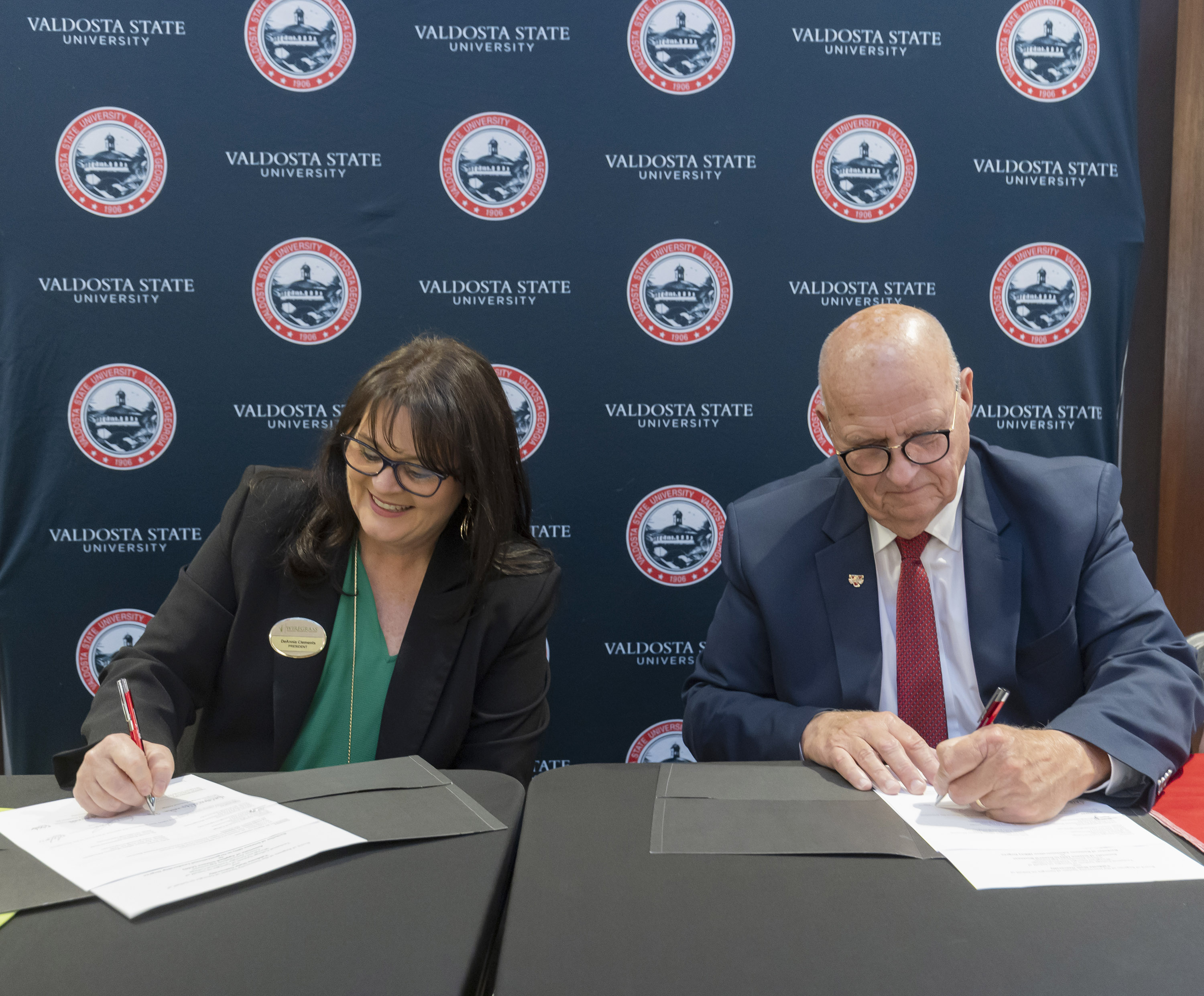 two people signing documents