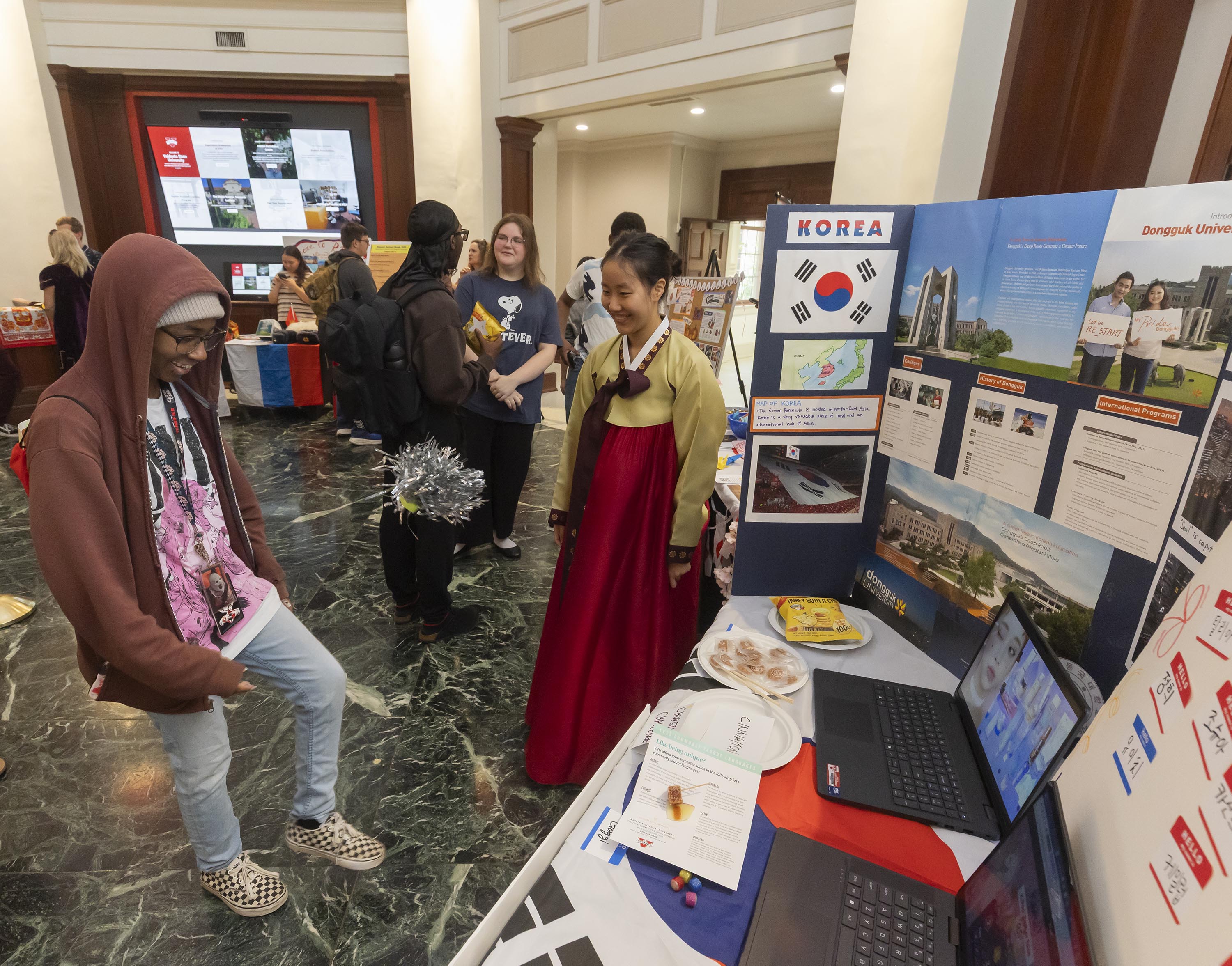 students standing at a display on korean language and culture