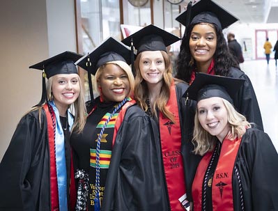 Five VSU students posing for picture at Commencement ceremony