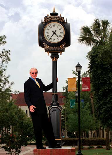 Ronald M. Zaccari poses on an outdoor clock