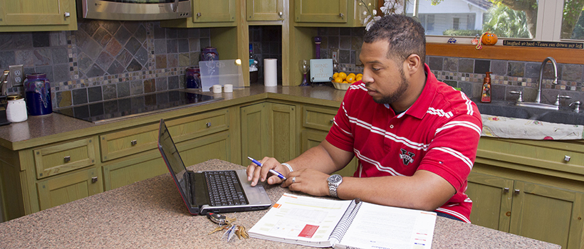 Man in kitchen studying