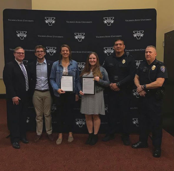 Dr. Vince Miller, President Jacob bell, Madelyn Corazza, Marlaina Wilkinson, Sergeant Jesus Arreola, and Officer Kenny McDonald posing for a photo when Miss Corazza and Miss Wilkinson were recognized