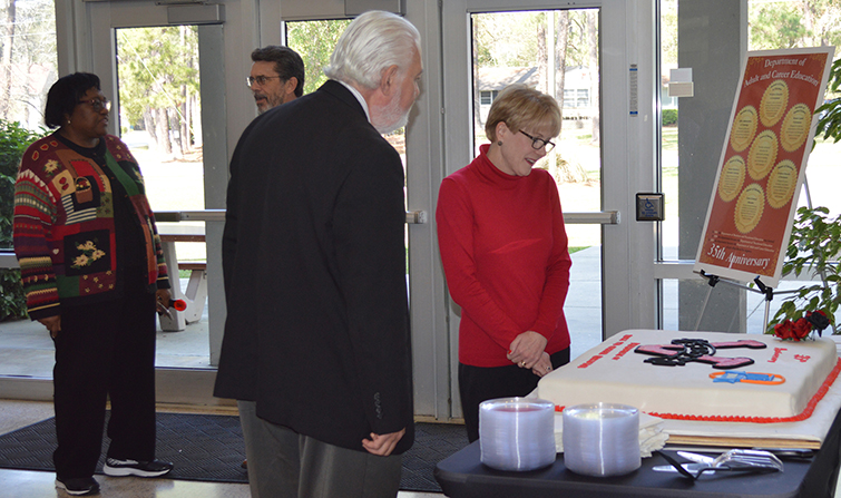 Dr. Martinez and COEHS Dean Minor admire cake