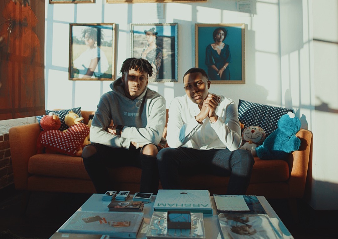 Adrian Scott and Dexter Davis sit on a couch in Cam Kirk Studios in Atlanta, Georgia. 