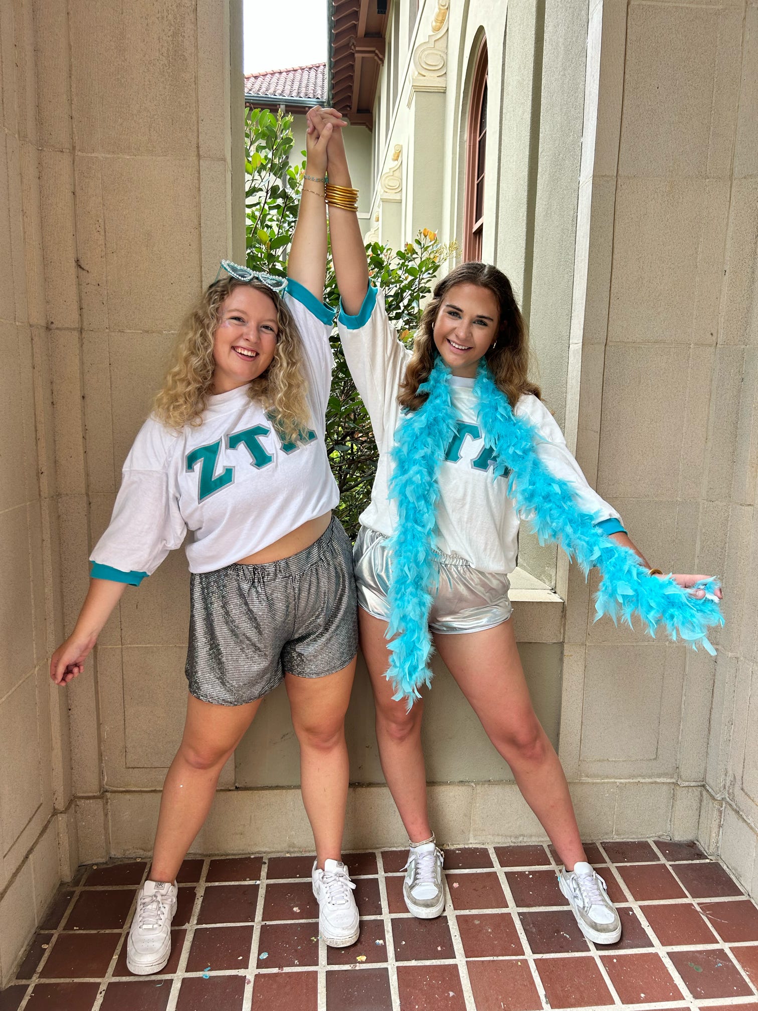 Two girls holding hands up