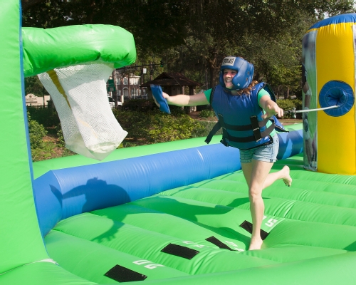 Student playing on an inflatable game at The Happening