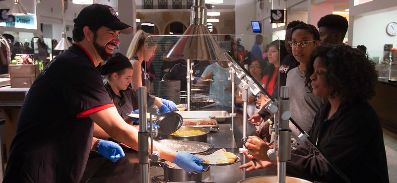 Dr. Carvajal serving students at Palms Dining.